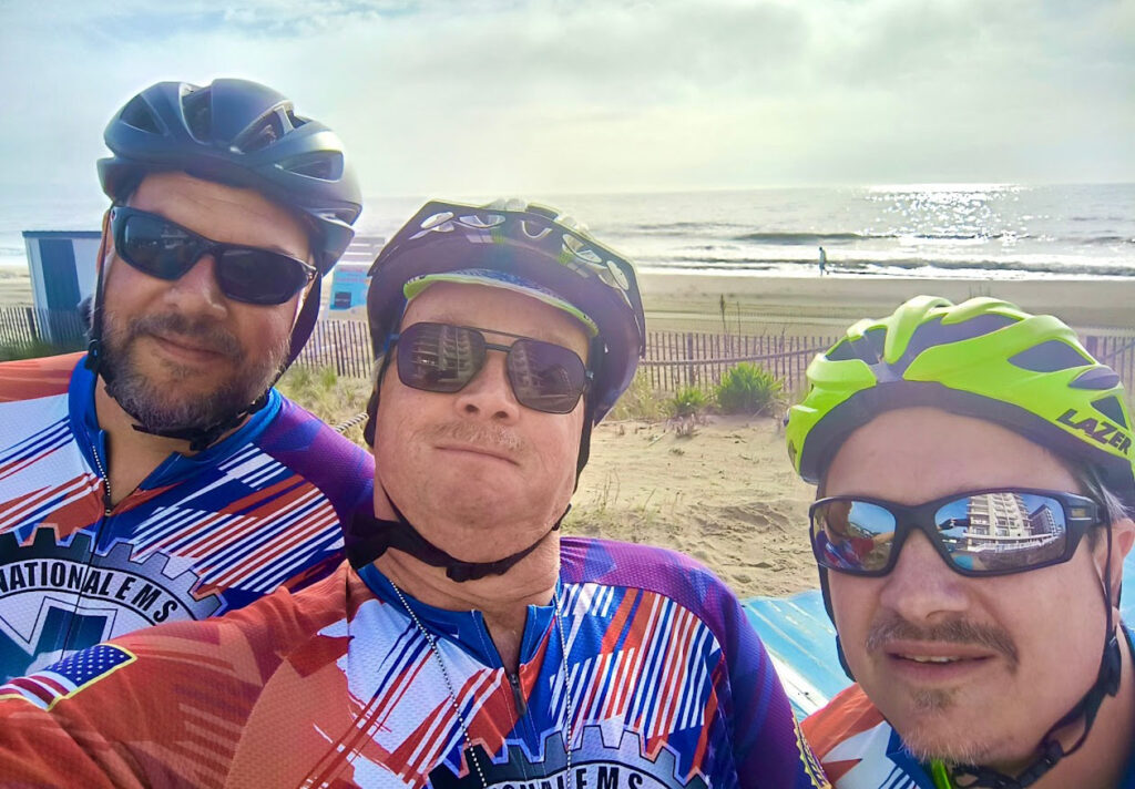 Bikers pose with beach in background