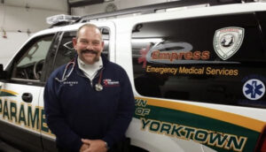 Man stands in front of SUV paramedic fly car.